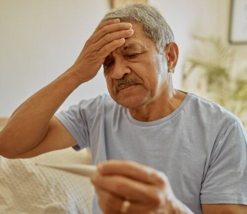 Man with fever holding head