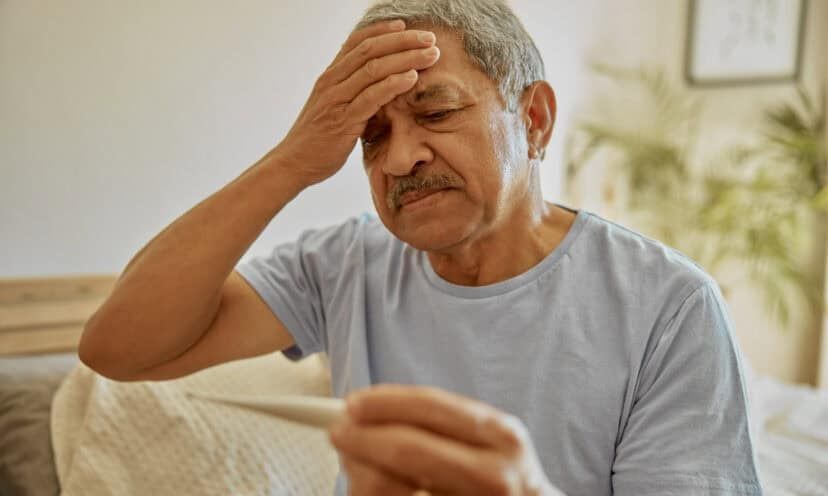 Man with fever holding head
