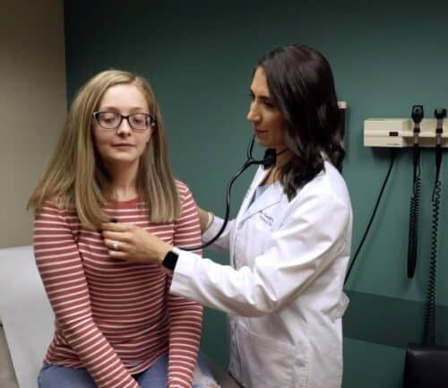 Dr. Lila Gwin listens to a patient's heart
