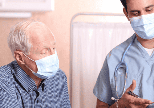Masked senior and physician speak