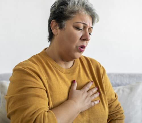 Woman holding her chest with shortness of breath