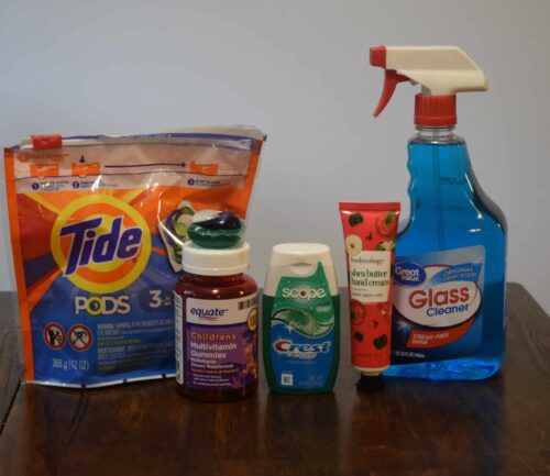 Tide pods, gummy vitamins, toothpaste, lotion, and window cleaning liquid in a row