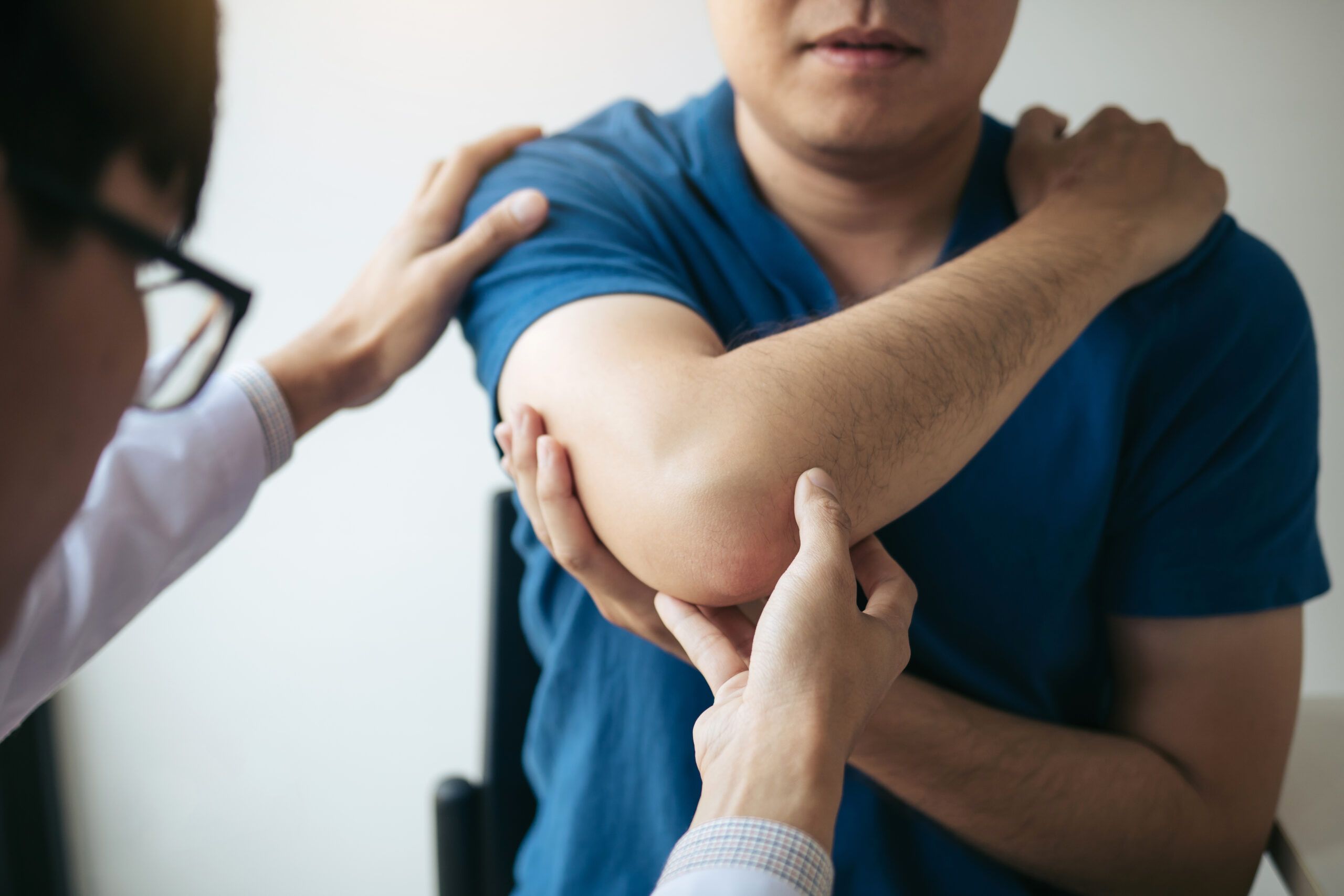 Physical therapists are checking patients elbows at the clinic office room.