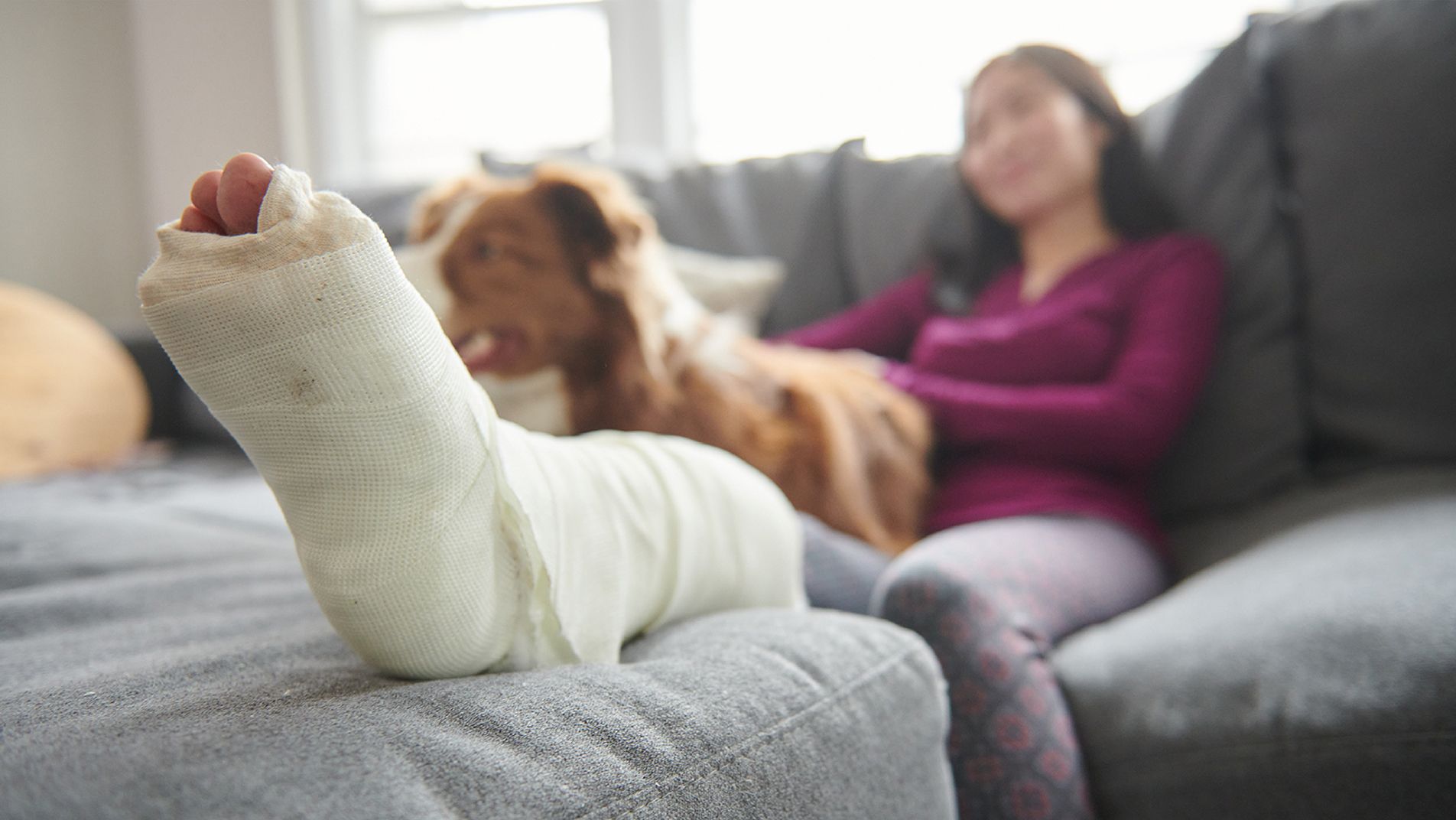 Injured woman on the couch with her dog