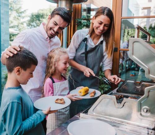 Cheerful mother making barbecue for her family in the backyard.