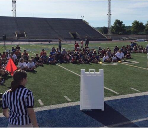 Students sit on football field