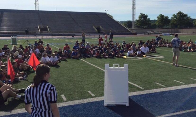 Students sit on football field