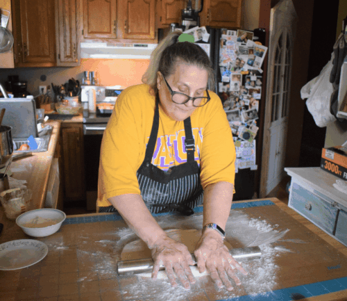 Woman rolls out dough by hand