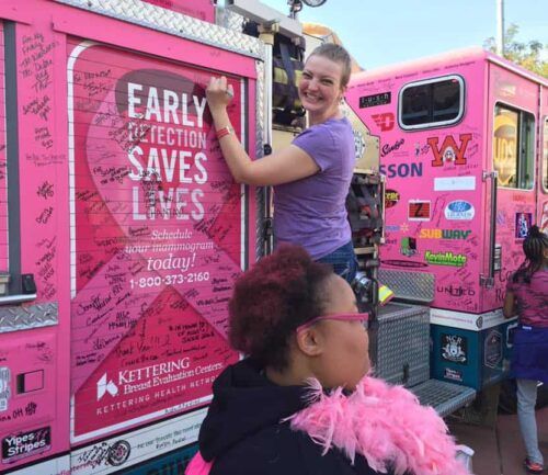 Melissa Lewis signs the pink truck at Making Strides