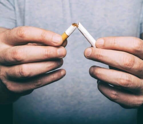 Man crushing cigarette to quit smoking