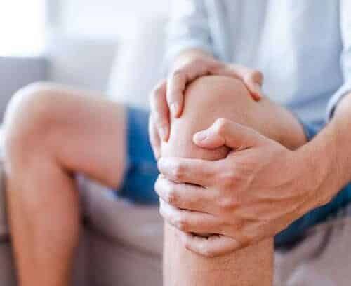 joint health: person holds knee in pain