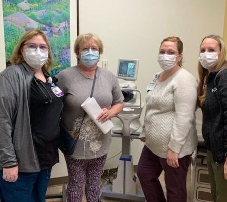 primary care staff around diabetic eye screening machine