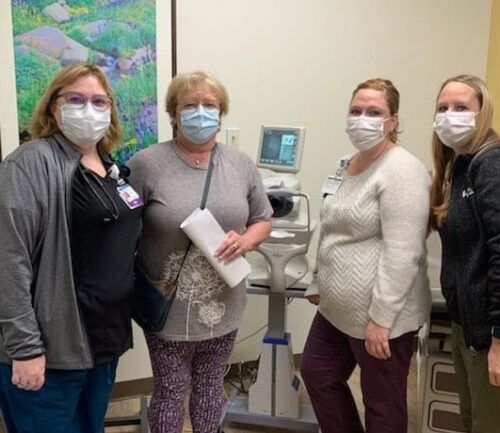 primary care staff around diabetic eye screening machine