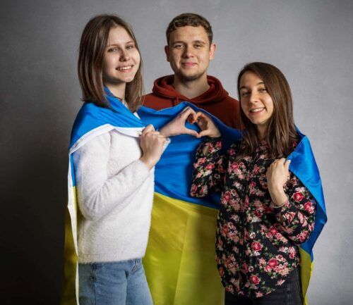 Ukrainian students drape their flag over their shoulders