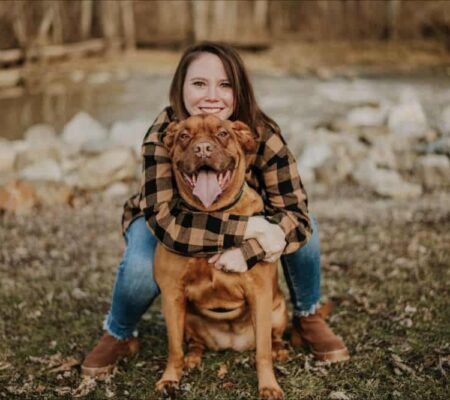 Virginia Chappius hugging her dog outside