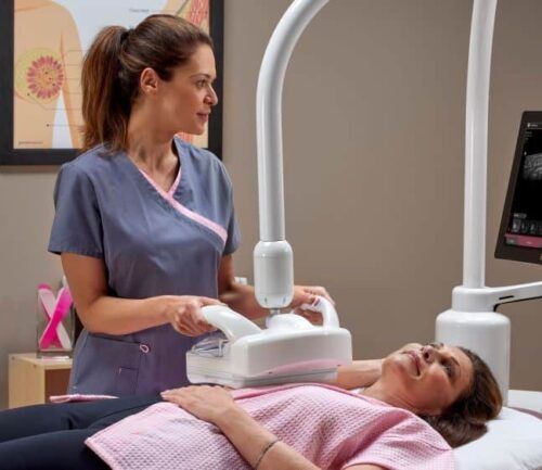 Woman performing breast screening with ABUS machine