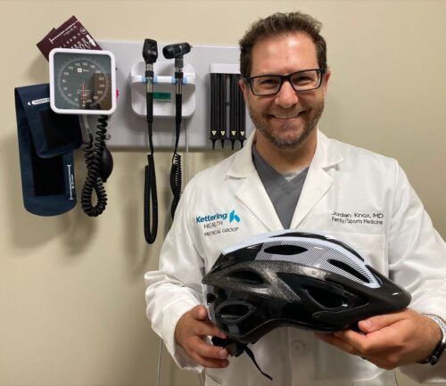 Dr. Jordan Knox holding a helmet