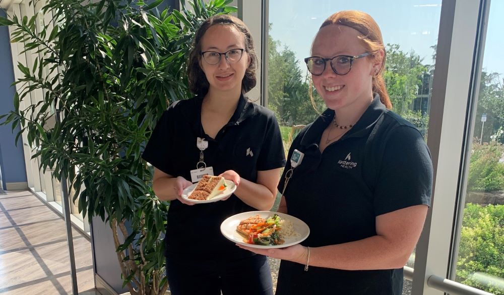 two members of culinary care team showing new food