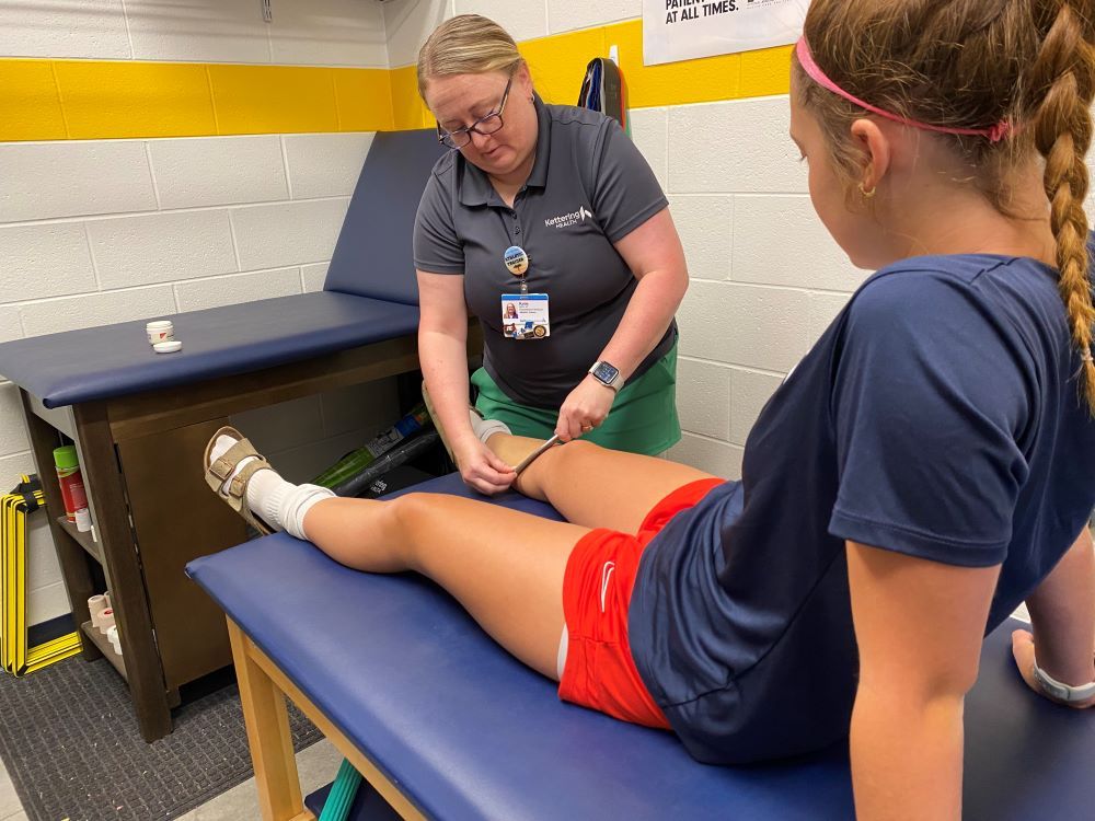 Katlie LaRue-Martin, Athletic Trainer, tends to student-athlete injury