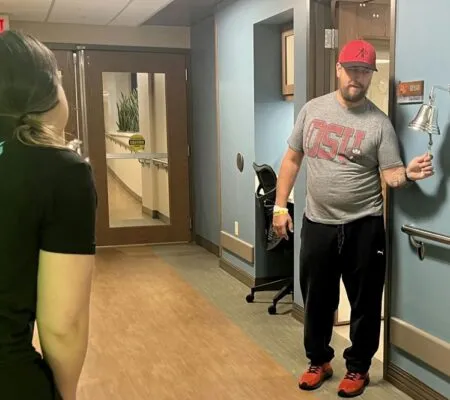 Bill Wooley ringing the inpatient rehabilitation bell at Kettering Health Hamilton