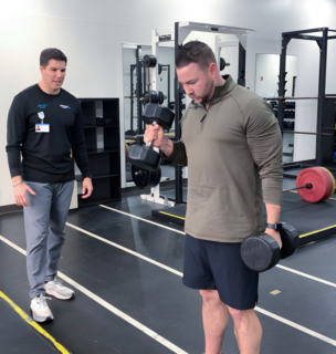 Rex Carpenter coaching a man lifting weights to help him reach his fitness goals