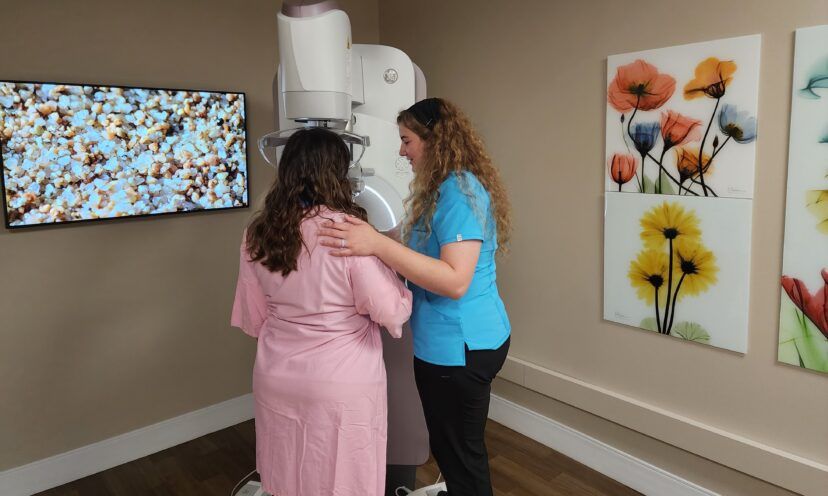 Patient getting a mammogram assisted by technologist