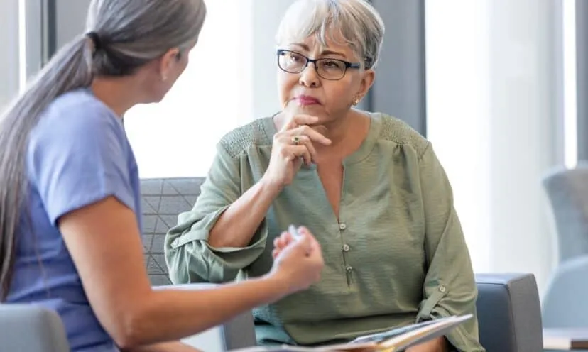 elderly woman talking to doctor waiting room