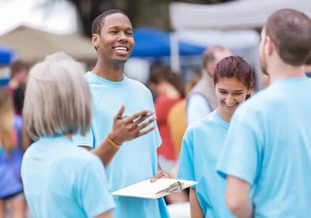 Community outreach leader giving instructions at outdoor festival or market