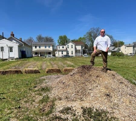 Bruce Kidney standing on dirt mound in unity garden