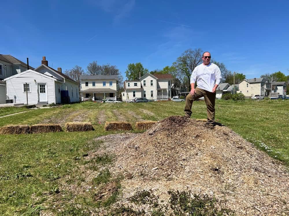 Bruce Kidney standing on dirt mound in unity garden