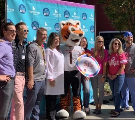 Event attendees posing for a picture with Who Dey, the Cincinnati Bengals mascot.