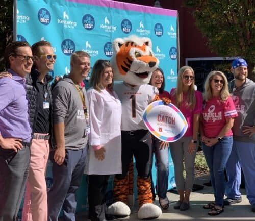 Event attendees posing for a picture with Who Dey, the Cincinnati Bengals mascot.