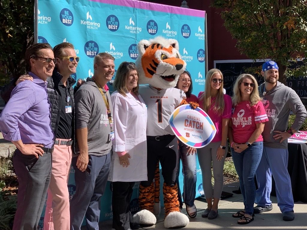 Event attendees posing for a picture with Who Dey, the Cincinnati Bengals mascot.