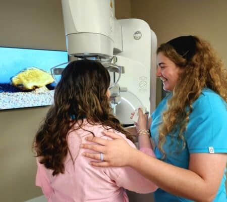 Woman doing patient-controlled compression during a mammogram