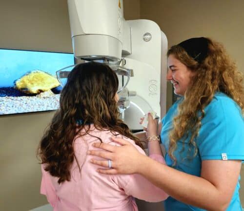 Woman doing patient-controlled compression during a mammogram