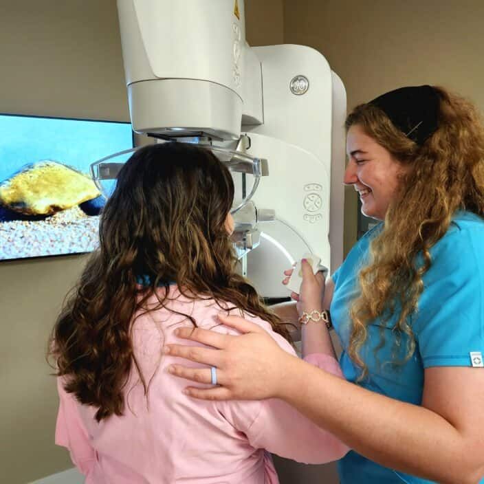 Woman doing patient-controlled compression during a mammogram