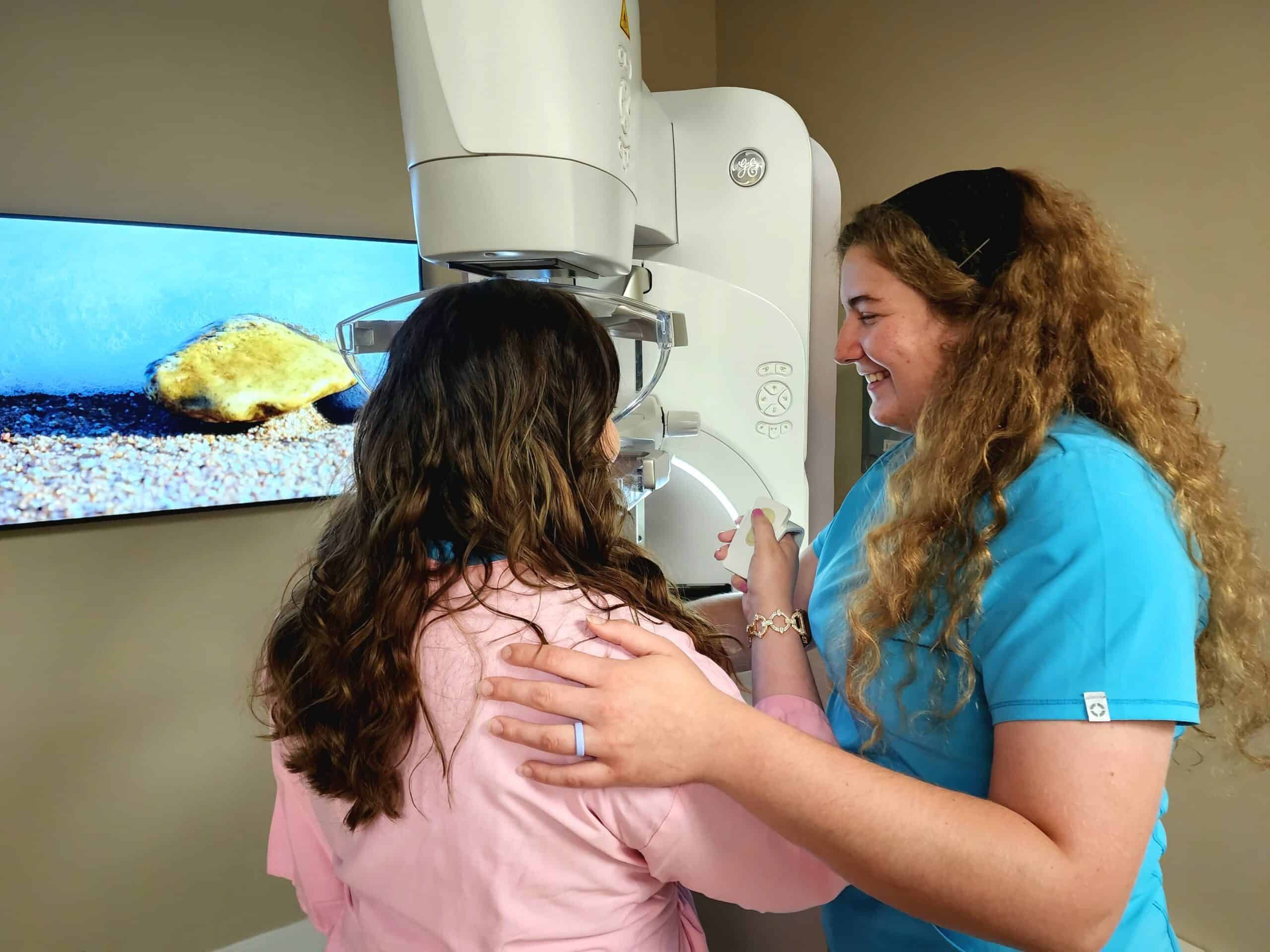 Woman doing patient-controlled compression during a mammogram