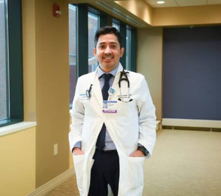 Dr. Juan Linares smiling at camera in hallway