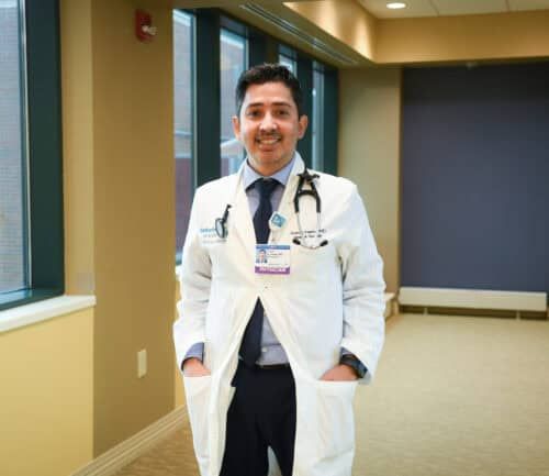 Dr. Juan Linares smiling at camera in hallway