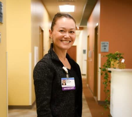 Dr. Melissa Butler standing in hallway, smiling at camera