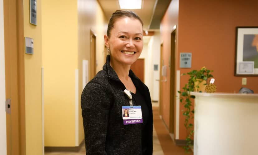 Dr. Melissa Butler standing in hallway, smiling at camera