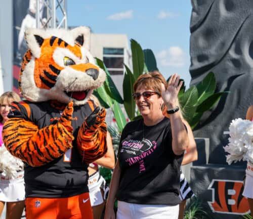 DeAnn Gallatin standing next to Who Dey while being honored as Hometown Hero.