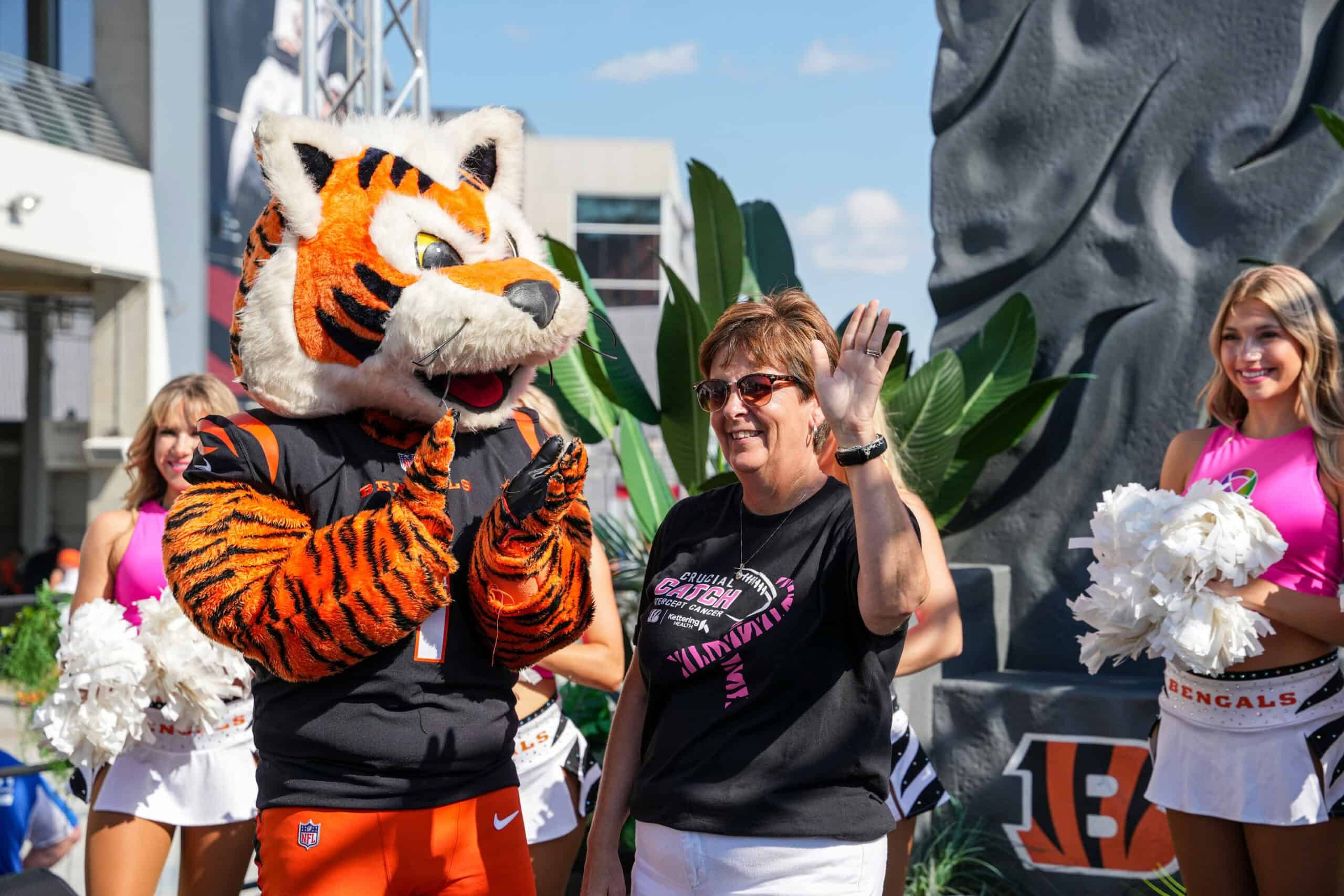 DeAnn Gallatin standing next to Who Dey while being honored as Hometown Hero.