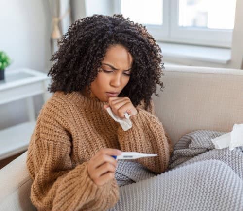 Woman on the couch checking her temperature