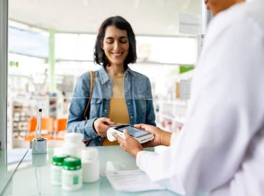 Woman paying by card while buying medicines at the pharmacy