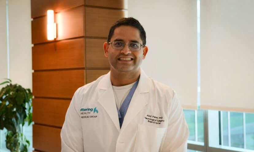 Dr. Akil Patel standing and smiling.