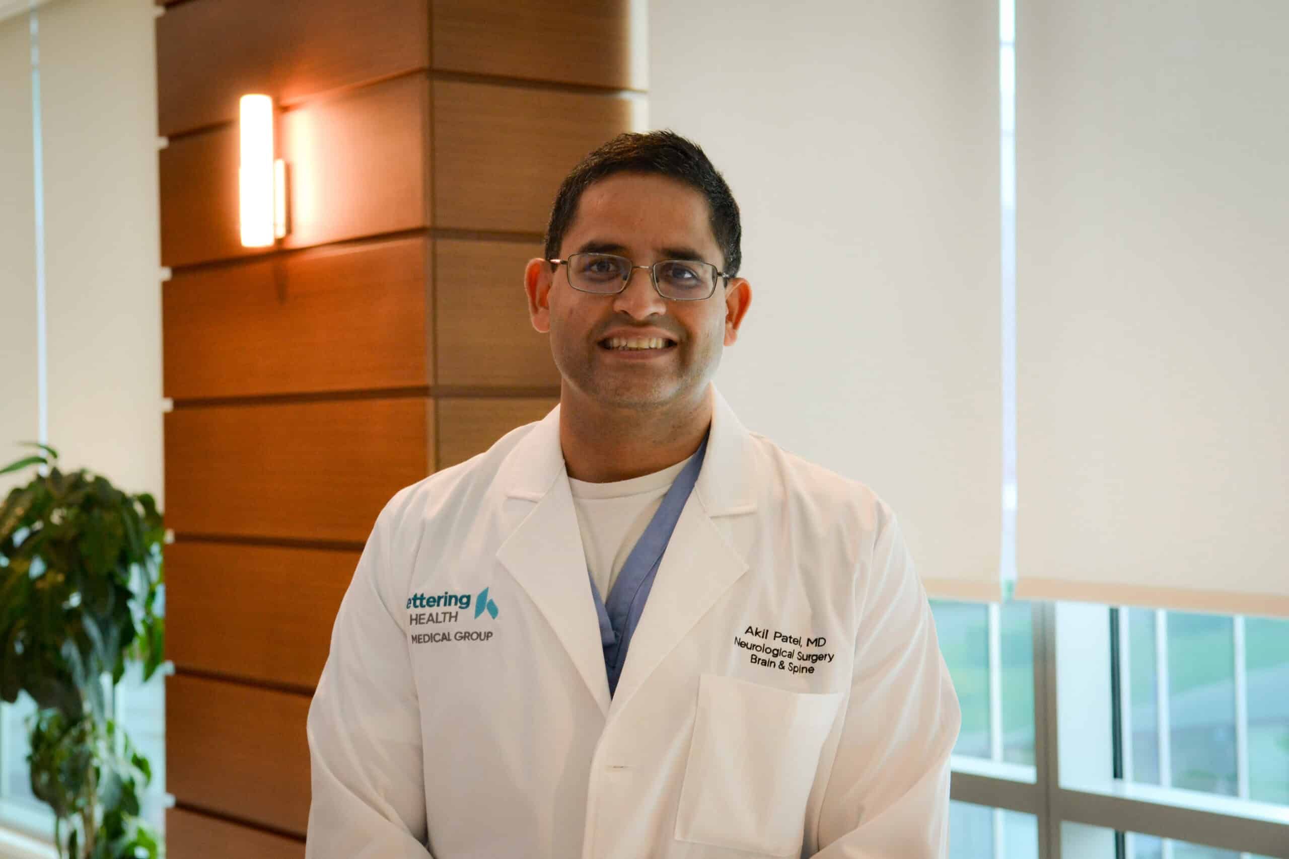 Dr. Akil Patel standing and smiling.