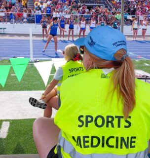 Sports medicine provider sitting on sidelines