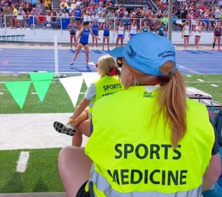 Sports medicine provider sitting on sidelines