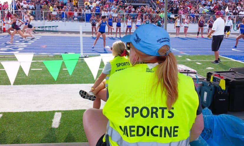 Sports medicine provider sitting on sidelines